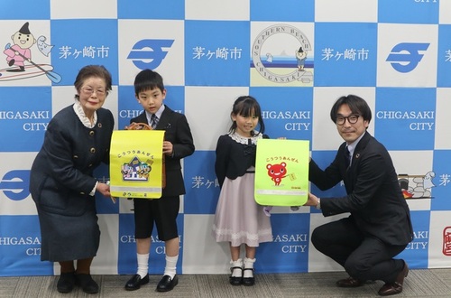 2:一般財団法人神奈川トラック協会様、日本コープ共済生活協同組合連合会様、ご寄贈いただいたランドセルカバーを付けたランドセルを持つ新1年生のお子さん