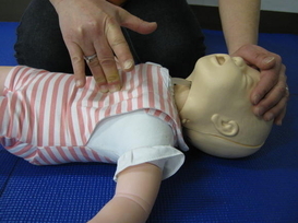 乳児の胸骨圧迫をしている写真