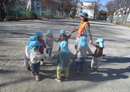 子どもの輪が鬼役の子を囲んでいる様子