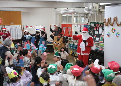 子ども達がサンタクロースと一緒に踊っている様子