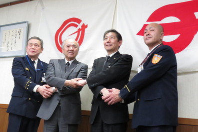 市長と寒川町長と両消防長が固い握手を交わしています。