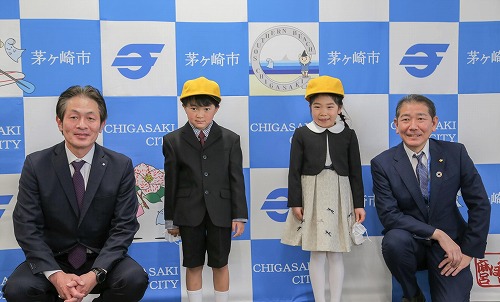 1:第一カッター工業株式会社様、佐藤市長、ご寄贈いただいた黄色い帽子を被る新1年生のお子さん