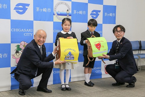 2:一般社団法人神奈川県トラック協会様、日本コープ共済生活協同組合連合会様、ご寄贈いただいたランドセルカバーを付けたランドセルを持つ新1年生のお子さん
