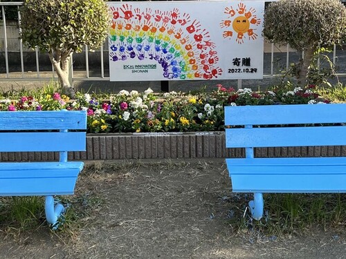 5:「写真」青いベンチに色とりどりの花と看板がとても映えます。