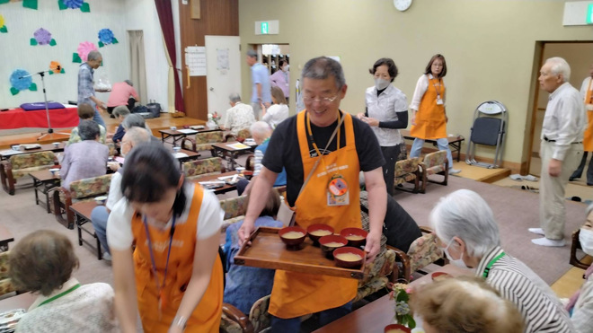 4:「ほのぼの小出」にてお味噌汁と共に笑顔を配る伊藤委員