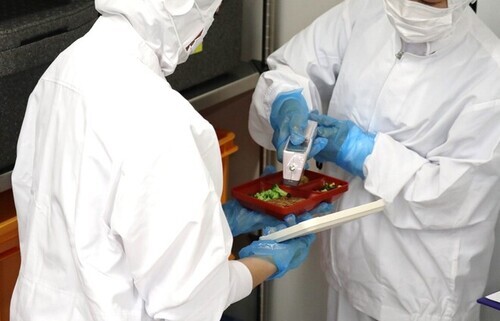 2:配膳員が給食を検温し、衛生管理の状況を確認・記録します。