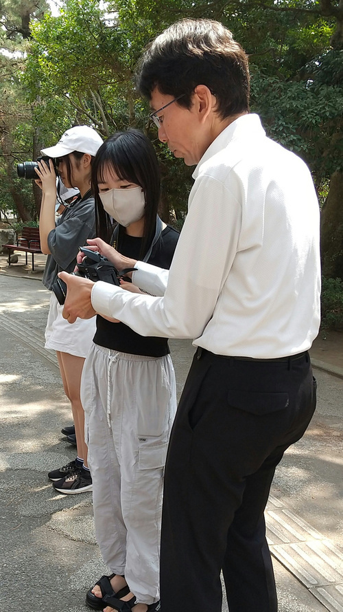 4:記者からカメラの使い方について教わる参加者