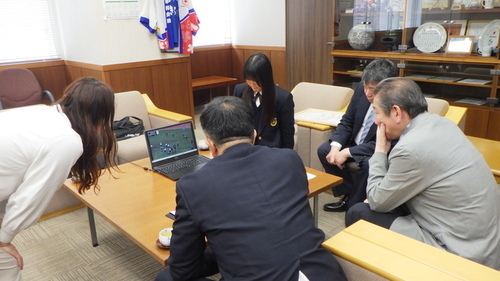 3:（画像）大会映像を見る市長と水島議員