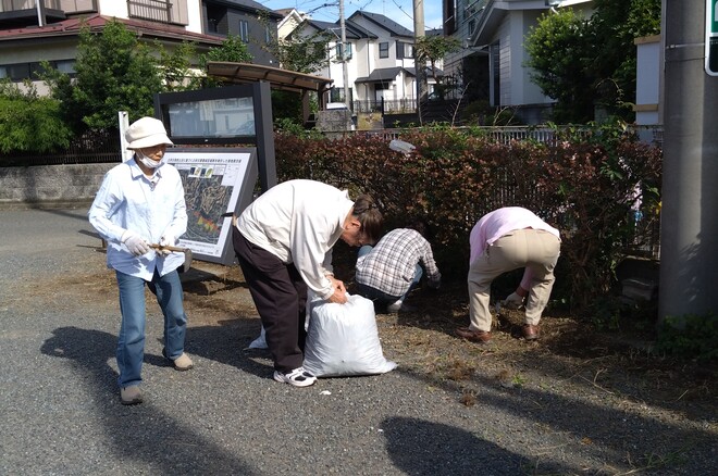 (画像）協力しながら、公民館の敷地内の雑草を取り除きます
